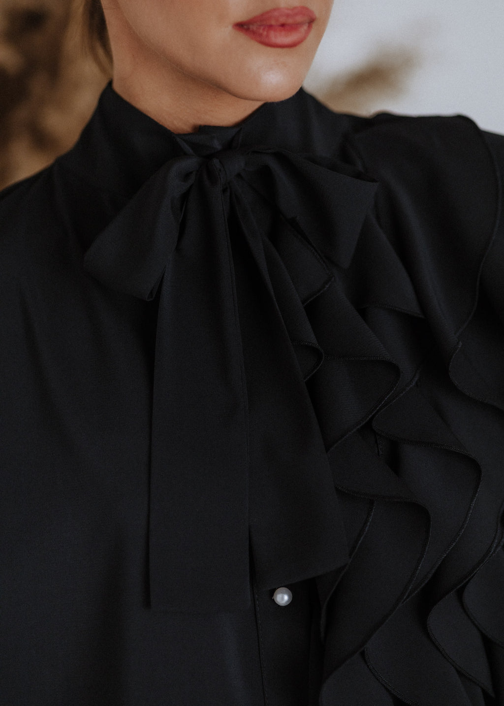 Black ruffled blouse with curls