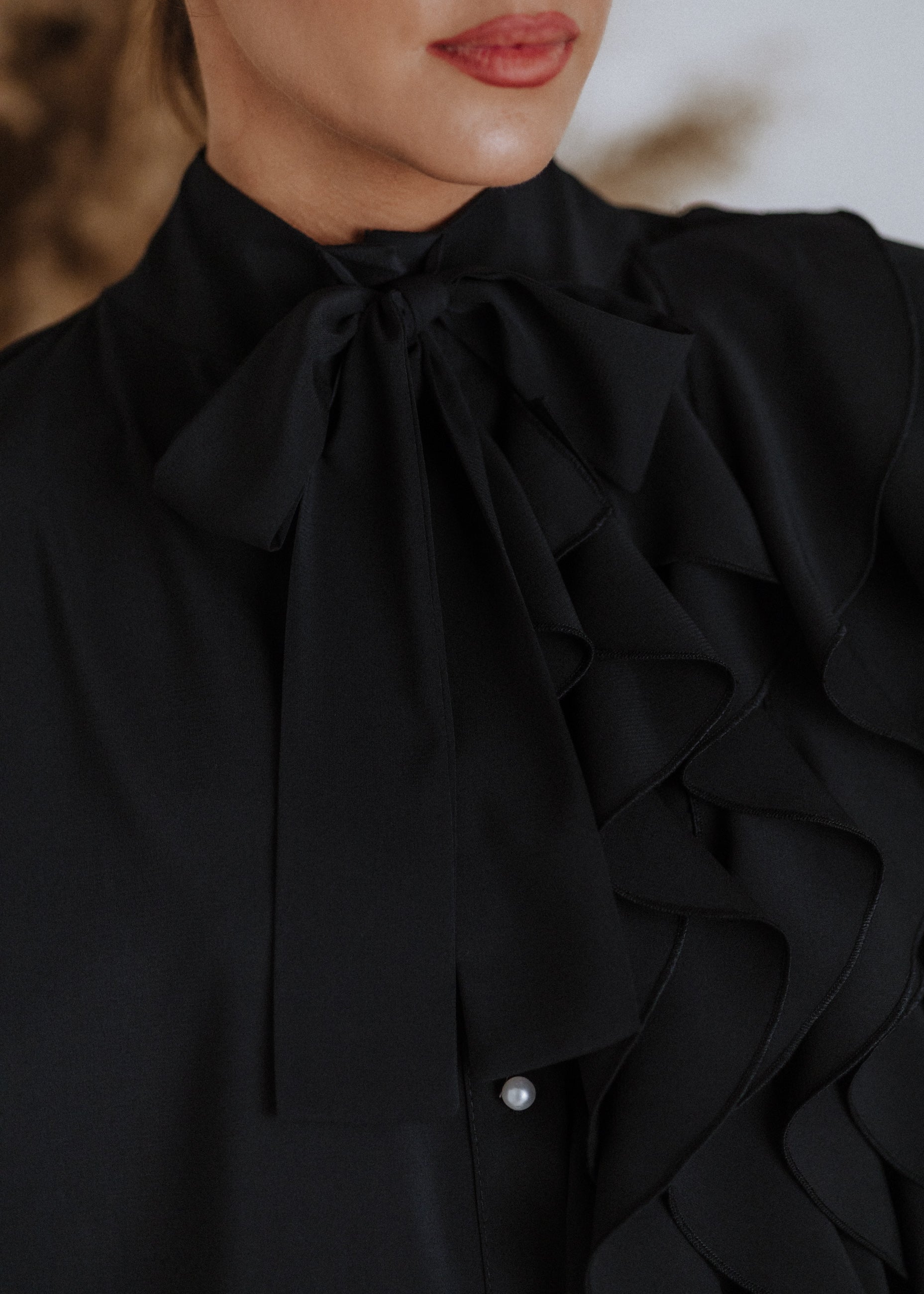 Black ruffled blouse with curls