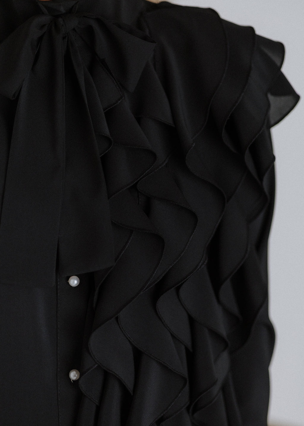 Black ruffled blouse with curls
