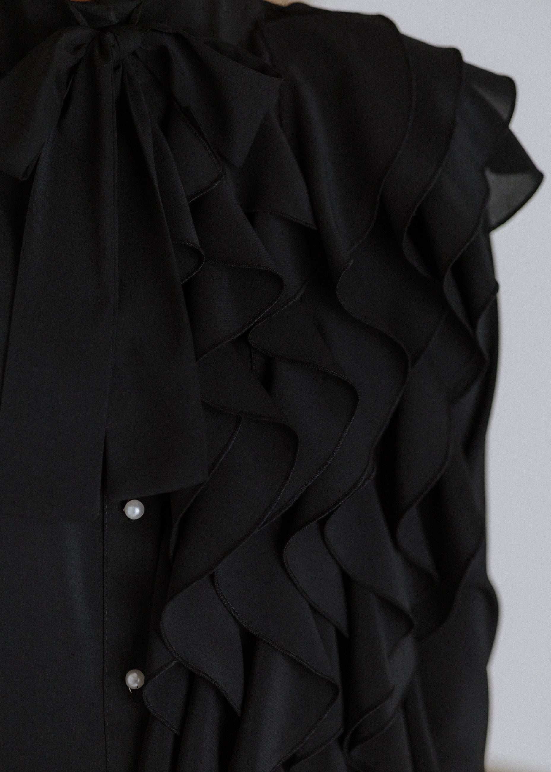 Black ruffled blouse with curls